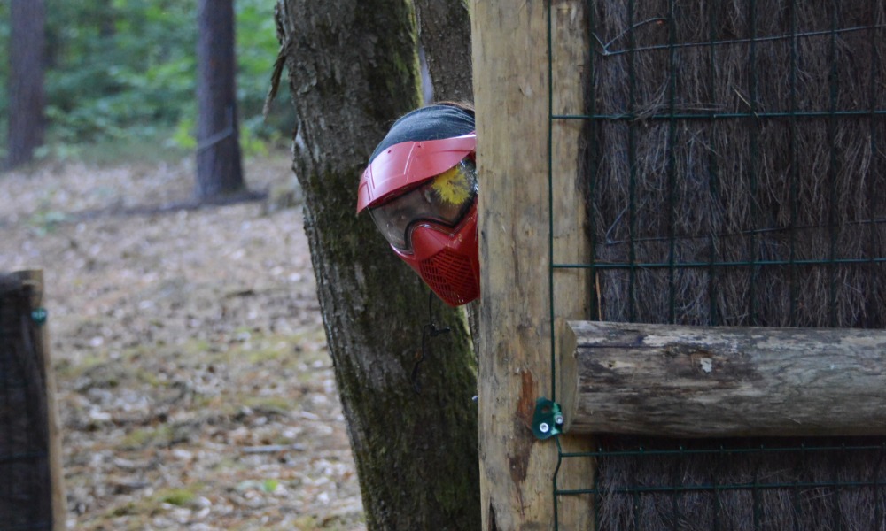 un joueur se cache derrière une palissade au paintball